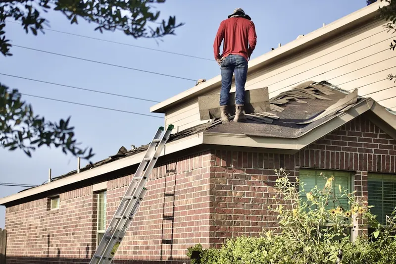 Professional roofer working on a residential roof in Lake Success